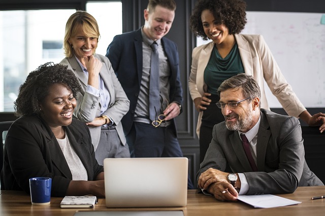 Group of workers looking at a laptop